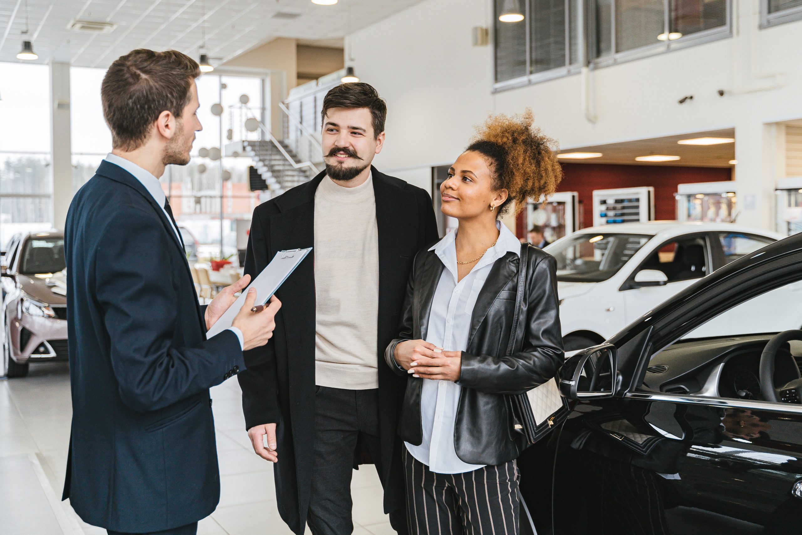 Couple discute achat voiture avec vendeur