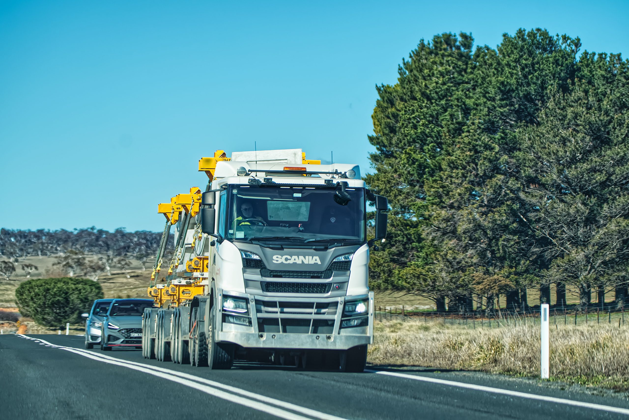 Camion Scania roulant sur route rurale ensoleillée