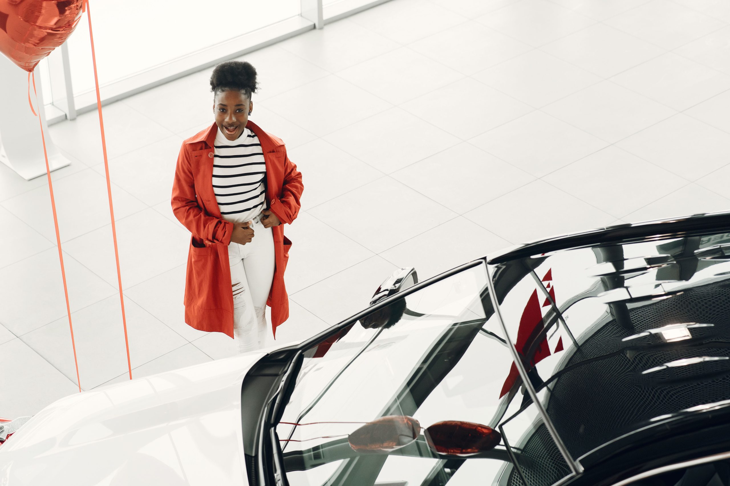 Femme enthousiaste découvrant nouvelle voiture concessionnaire