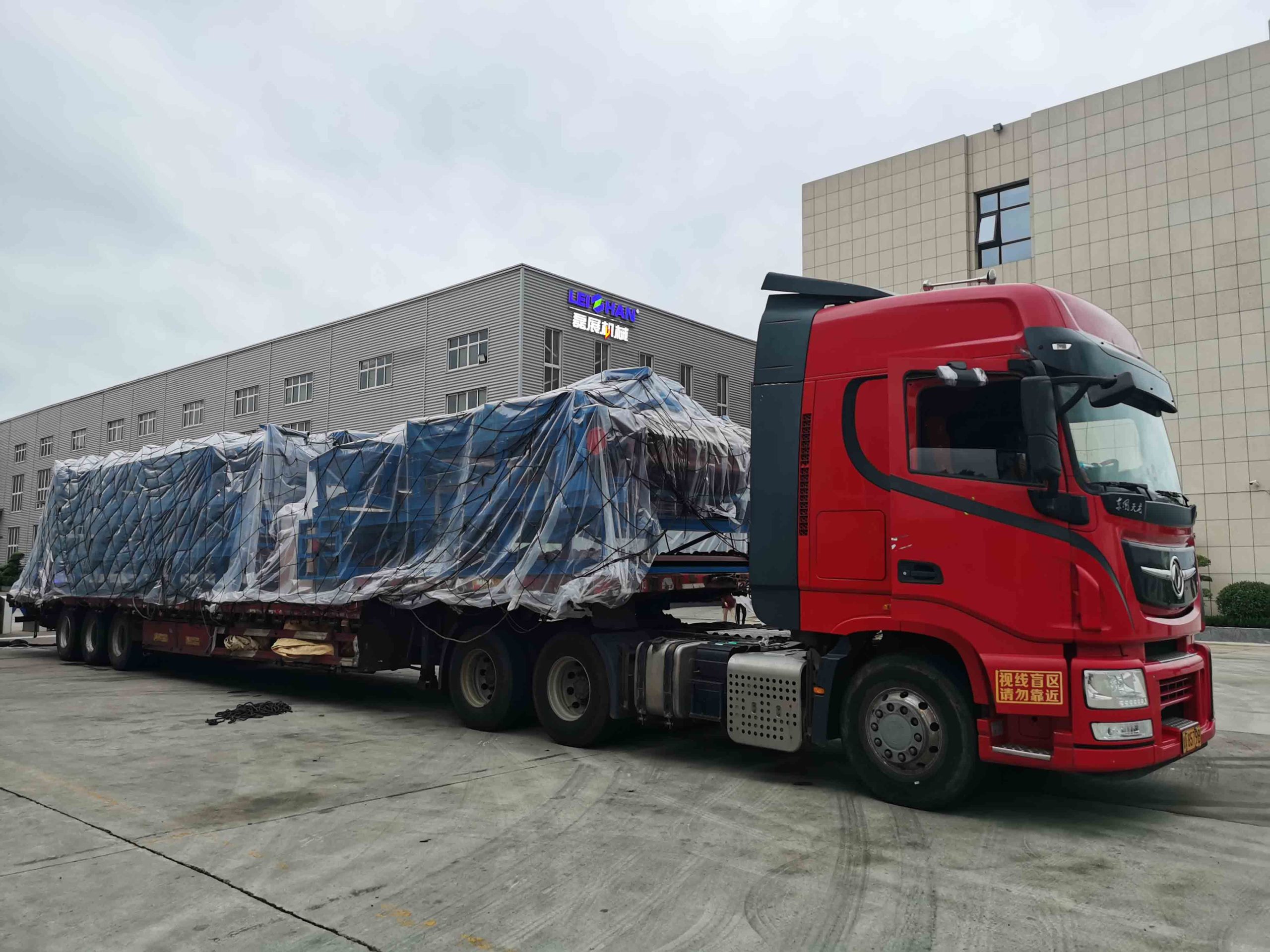 Camion rouge chargement couvert zone industrielle