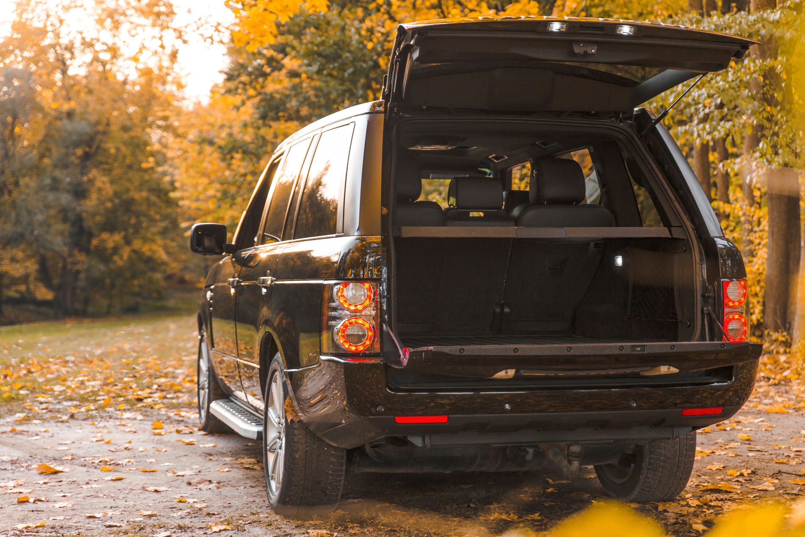 SUV noir coffre ouvert forêt automne