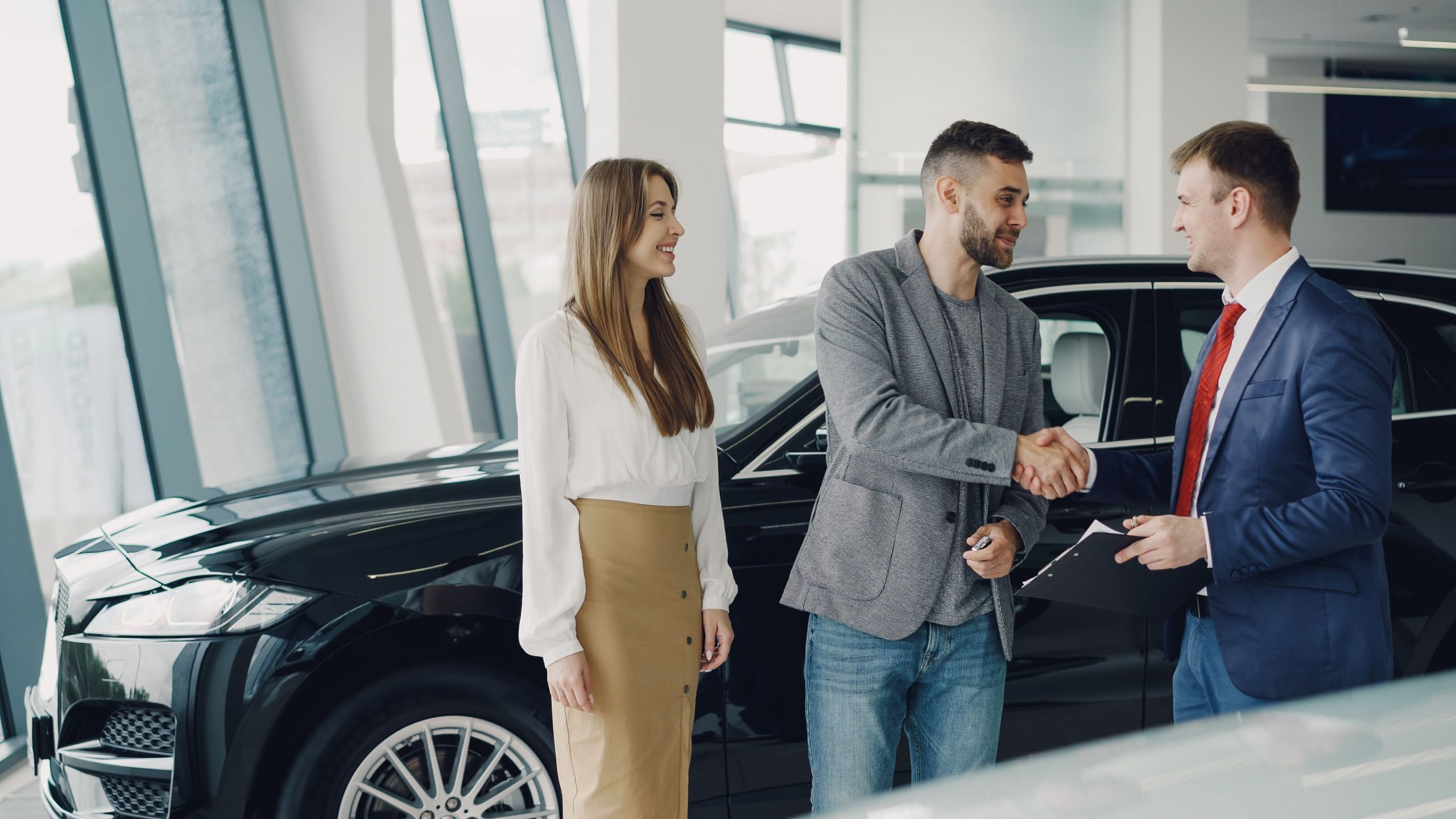 Clients serrent main vendeur concessionnaire