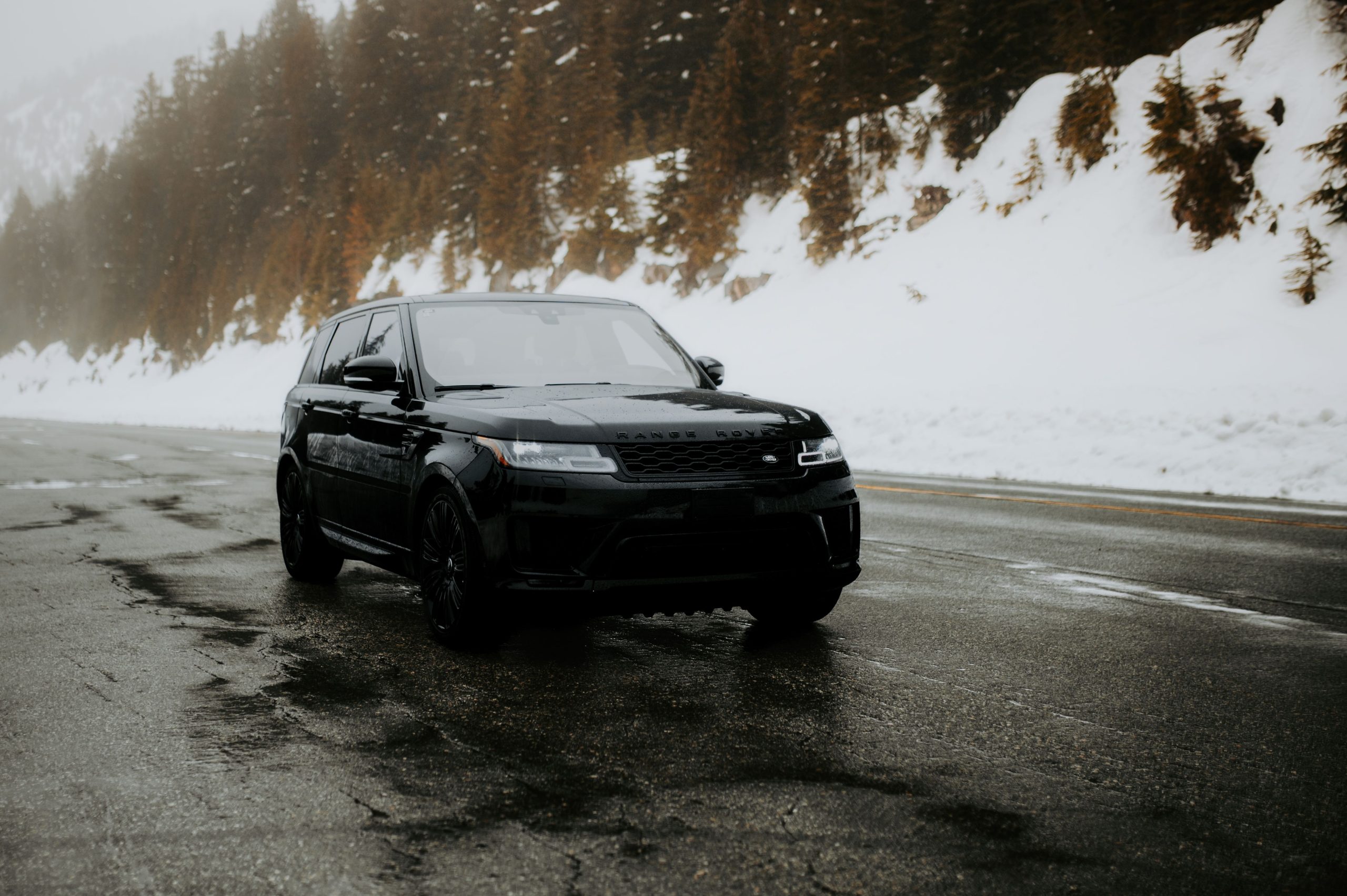 SUV noir naviguant route montagneuse enneigée