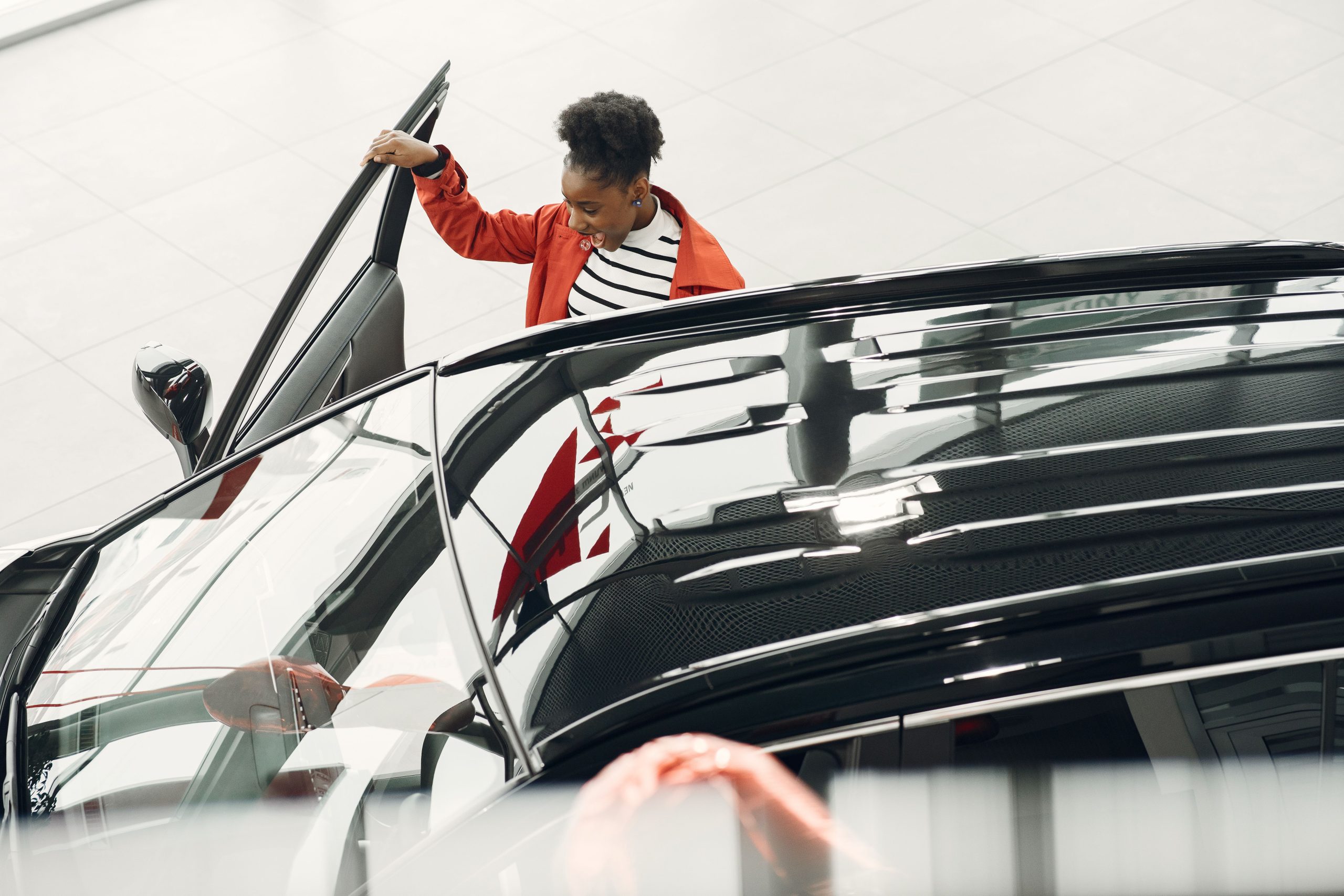 Femme ouvre portière voiture concession moderne