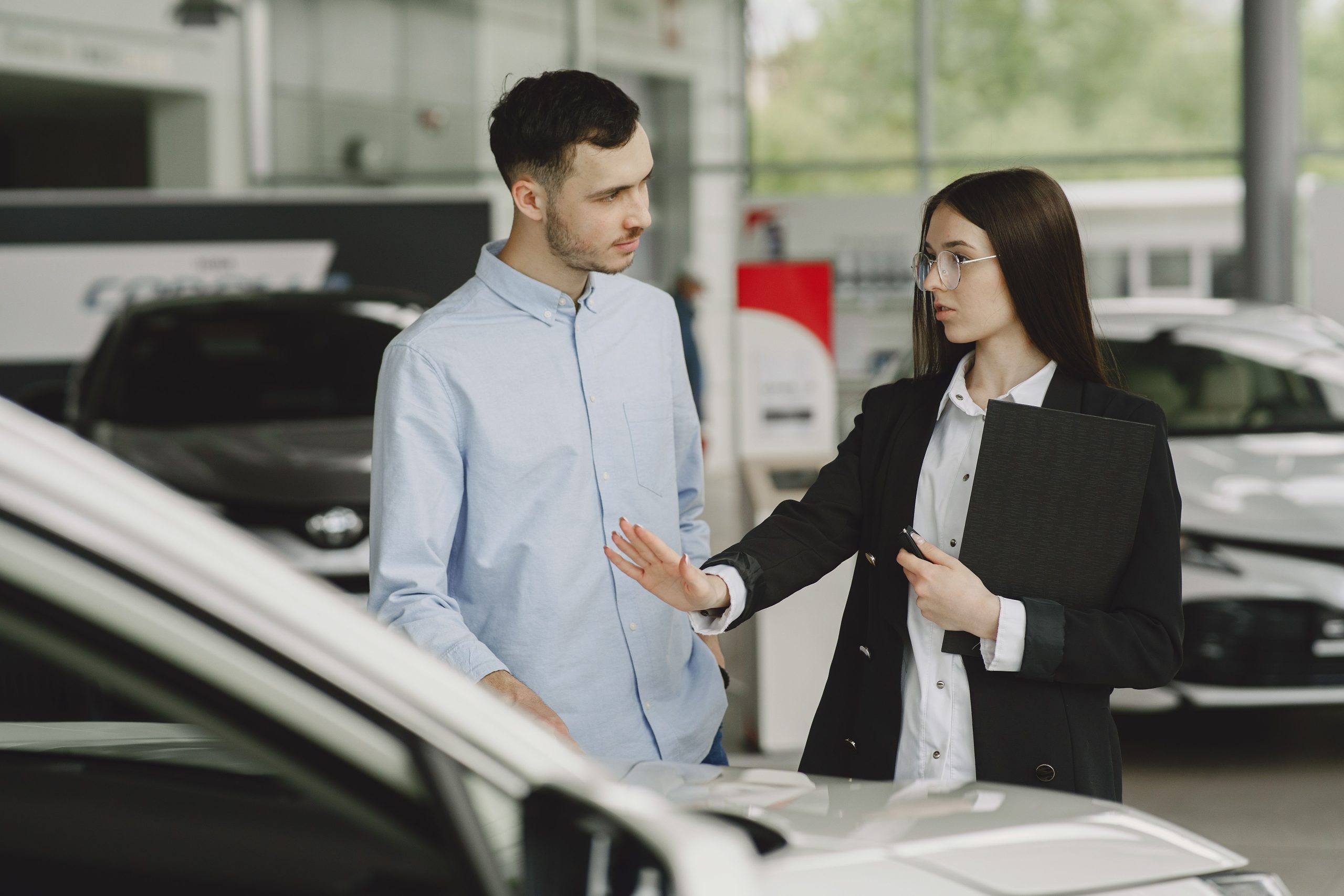 Vendeur explique caractéristiques auto au client
